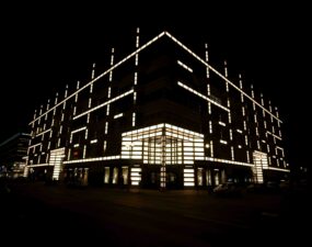 Beleuchtetes Gebäude an der Friedrichstraße in Berlin mit OLED-Fassadenbeleuchtung bei Nacht.