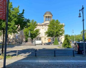 Außenansicht der Alten Nationalgalerie in Berlin bei Tageslicht mit Blick auf die Kuppel und umliegende Bäume.