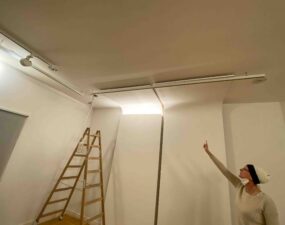 Abstimmung zur Lichtausrichtung im Museum Berggruen mit Strahlern, Leiter und Lichttest an einer Gewölbedecke.