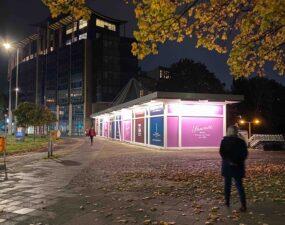 Fassadenbeleuchtung eines Pavillons mit beklebter Fassade des Schokoladenherstellers Sawade.