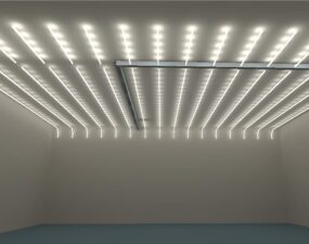 Innenraum mit gleichmäßigem Raster aus vertikal verlaufenden LED-Lichtlinien an Decke und Wand in einem Gebäude am Kurfürstendamm in Berlin.
