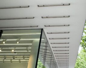 Außenansicht eines Ladengeschäfts mit regelmäßiger Anordnung von Lichtleisten unter dem Vordach.