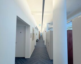 Modern beleuchteter Büroflur mit eingelassener Deckenleuchte.