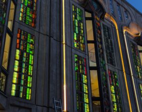 Fassade des Friedrichstadt-Palasts in der Dämmerung mit warmweißen LED-Lichtlinien entlang der Lisenen